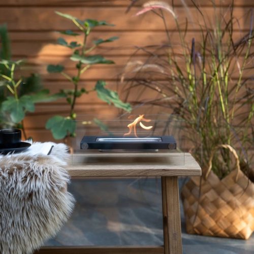 Szabadon álló asztali füstmentes biokandalló otthoni kertbe, fekete díszítő kövekkel